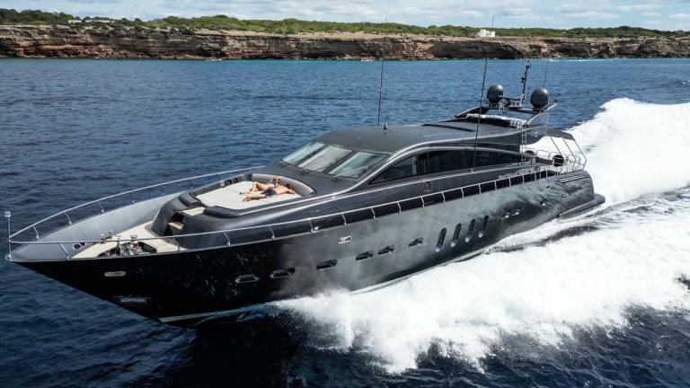 Die Motoryacht Dark Knight fällt mit ihrem modernen Design auf und fährt schnell über das Meer.