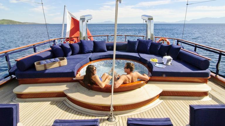 Woman and man in the jacuzzi on the upper deck of the gulet in fine weather