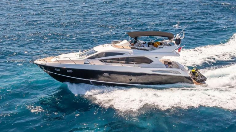 The motor yacht Midnight Summer Dream glides swiftly through blue waters, showcasing a stylish and luxurious design.