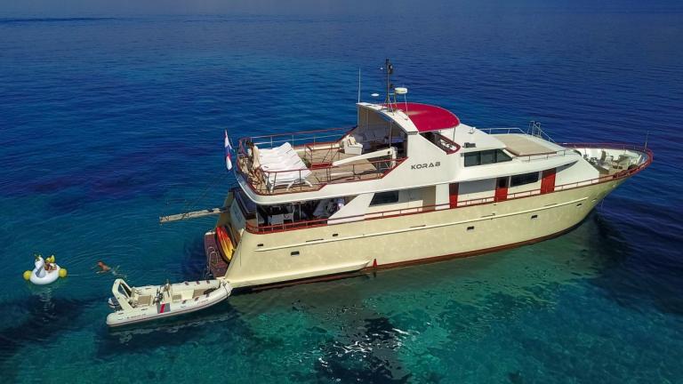 Motor yacht Korab is anchored in calm waters, offering elegant design and relaxing comfort.