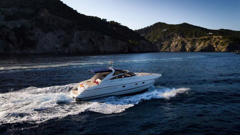 Sunshine motor yacht in motion near Ibiza is perfect for daily yacht hire in Spain.