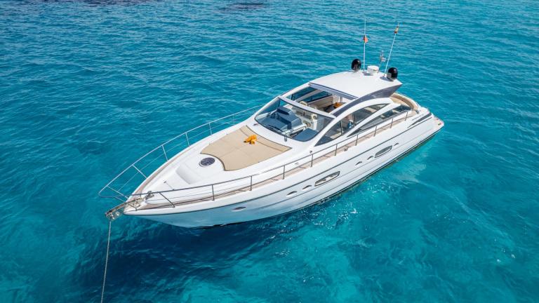 Ibiza’da demirli Fancy That motoryatın dış görünümü ve geniş güverte alanı.
