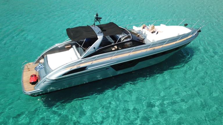 Die Motoryacht Este 2 liegt in türkisblauem Wasser bei Mykonos; an Deck sind großzügige Liegeflächen klar zu sehen.