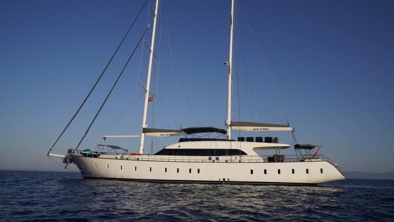 The impressive sailing yacht Queen of Makri glides majestically over the calm blue waters.