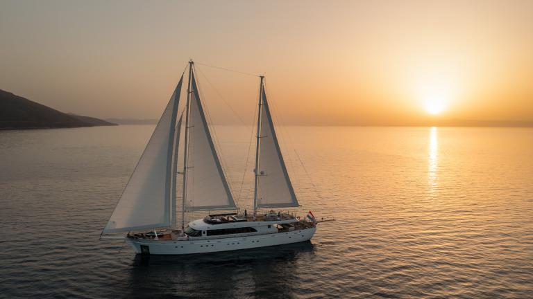 Split, Hırvatistan kıyılarında günbatımı sırasında Love Story motor yelkenlisi.