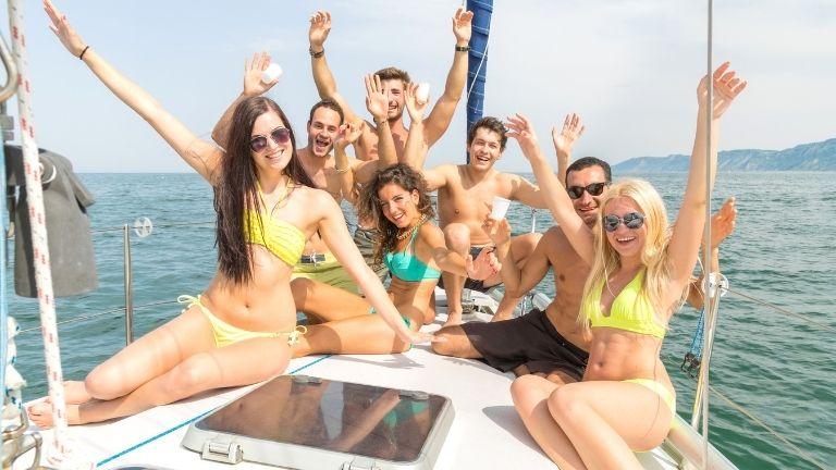 Eine Gruppe von Jungen und Mädchen verbringt im Urlaub Zeit zusammen auf der Yacht.