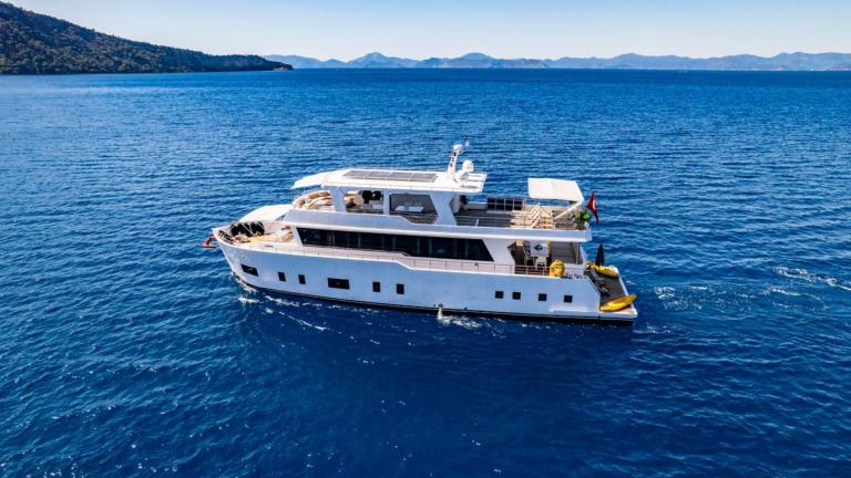 Lila trawler yacht moves slowly and comfortably on calm waters off Fethiye, Turkey.