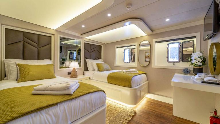 Stylish twin cabin with two single beds on the sailing yacht Queen of Makri, perfect for restful nights.