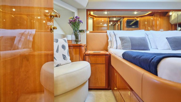 Luxurious bedroom with a large bed, elegant decor, and cozy seating area on a yacht
