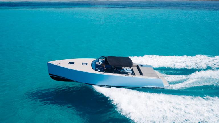 The Blue Steel motor yacht stands out with its sleek design as it speeds across the sea.