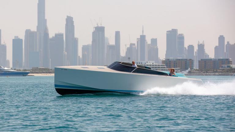 The motor yacht Lucky Me speeds through the water with a modern city skyline in the background.