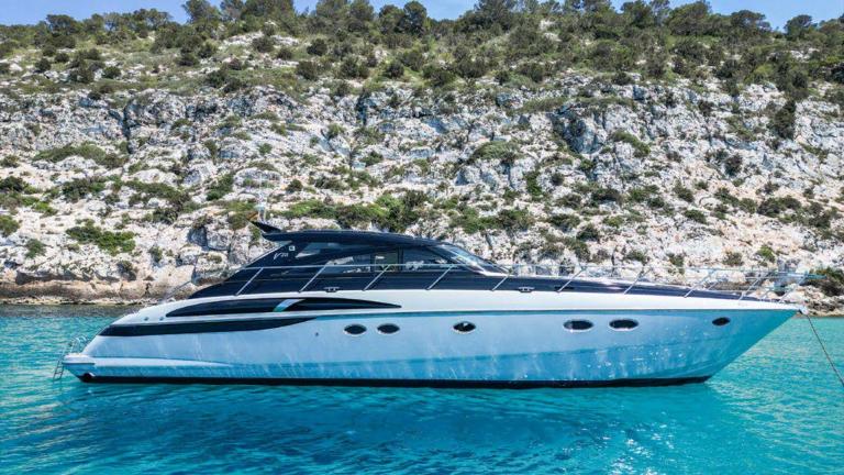 Motor yacht Make My Day is anchored in turquoise waters, standing out with its modern design.