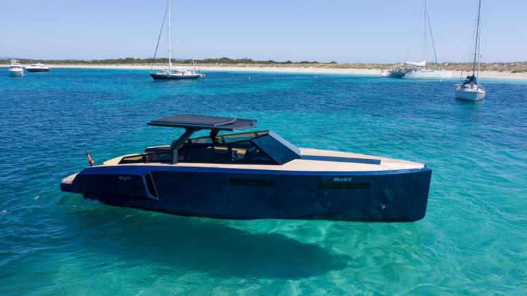 The Neve motor yacht is anchored in crystal-clear blue waters, standing out with its modern design.