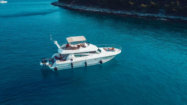 The motor yacht Unplugged anchored on clear blue waters.