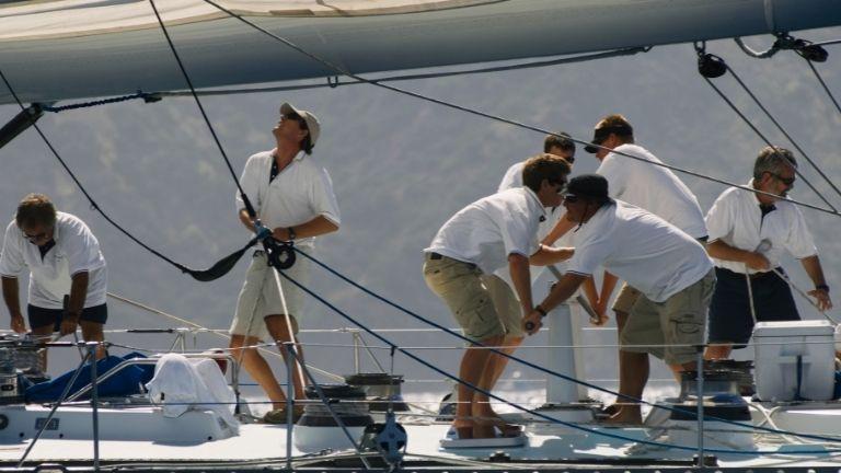 The crowded crew, dressed in the same color and type, prepares the yacht for the journey.