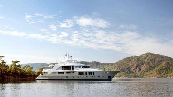 Photograph of a luxury charter motor yacht in a beautiful bay.