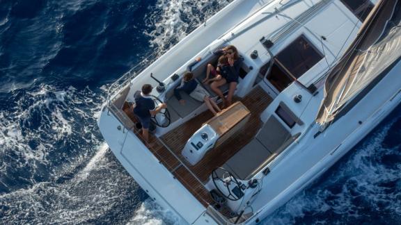 People sitting and chatting in the cockpit of Sky Asya yacht during a sea voyage.