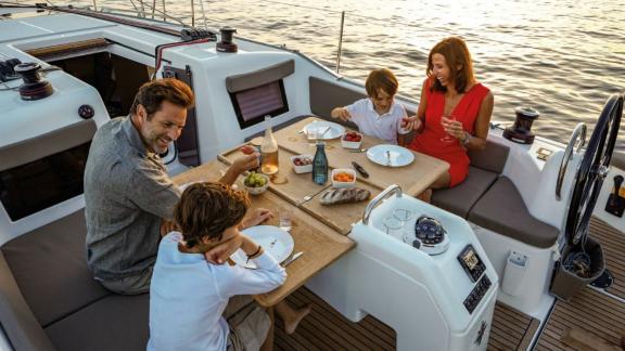 A family enjoying dinner on the aft deck of Sky Asya yacht at sea.