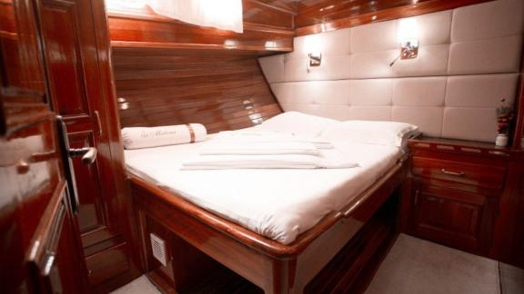 Comfortable cabin of the gulet Malena with double bed and wood panelling, Split, Croatia.