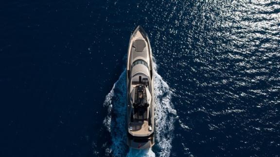 A bird's-eye view of a superyacht cruising and its upper deck.