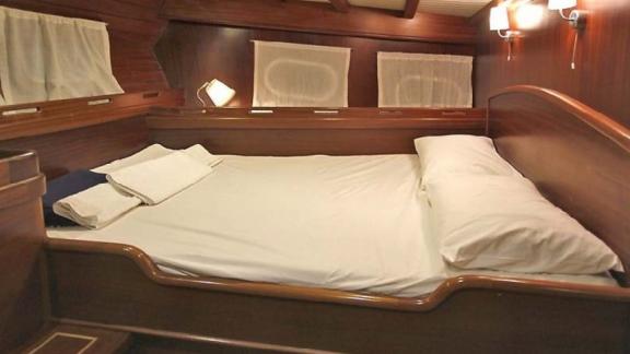 The spacious cabin on the gulet Larin Su offers a cozy atmosphere with wooden decor and a comfortable bed.