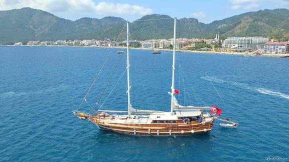 Gulet mit 8 Kabinen im Hafen von Marmaris, umgeben von der malerischen Küstenlandschaft und städtischer Skyline.