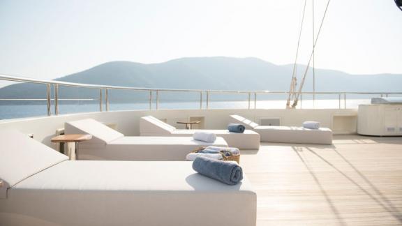 Luxuriöse Sonnenliegen auf dem Deck der Meira Segelyacht mit atemberaubendem Ausblick.