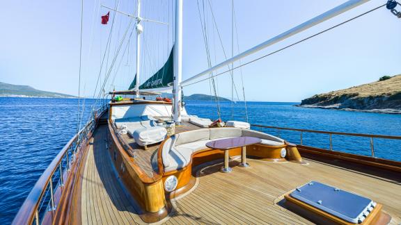 Elegante Gulet Lady Christa segelt auf blauem Meer, mit gemütlichem Holzdeck und schöner Küstenlandschaft im Hintergrund