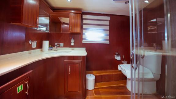 A stylish bathroom with a large countertop, toilet, and shower on a gulet.