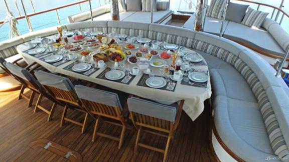 This gulet with 8 cabins in the harbour of Marmaris offers a spacious breakfast deck with a richly laid table for guests