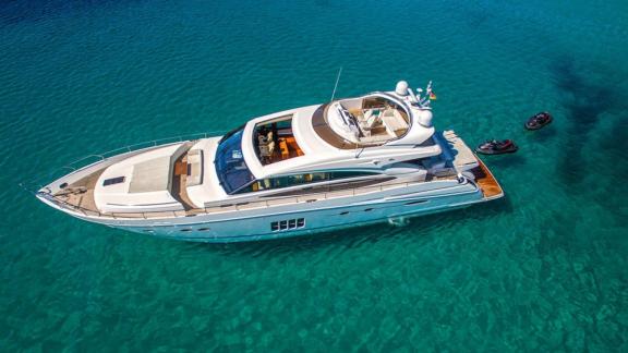 Via yacht stands out with its elegance and grace, visible from above in the clear sea water.