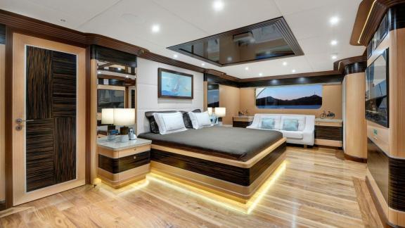 Spacious and elegant master cabin of the Meira sailing yacht with a king-size bed and panoramic windows.