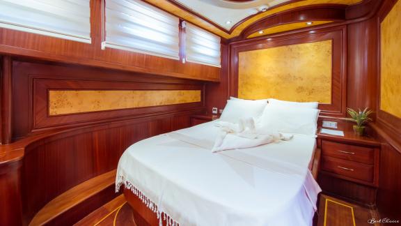 A comfortable cabin with a large double bed and stylish wood paneling.