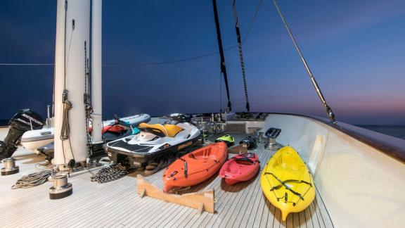 Diverse water sports equipment on the Meira sailing yacht, including jet-ski and kayaks.