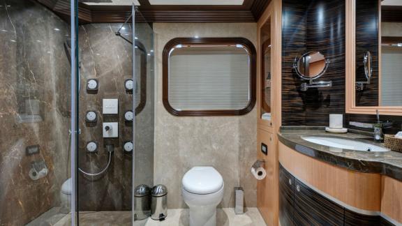 Элегантная ванная комната на яхте Meira с стеклянным душем и высококачественной сантехникой.