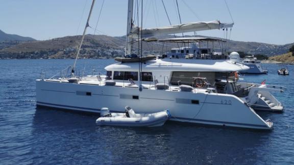 Lagoon 620 Katamaran, Bodrum'daki güzel bir koyda diğer yatların arasında sakin bir şekilde demirlemiş durumda.