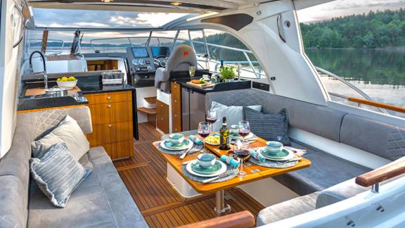 The seating area of motor yacht 7 Happy days stands out with stylish decor and comfortable seats. The dining table is re