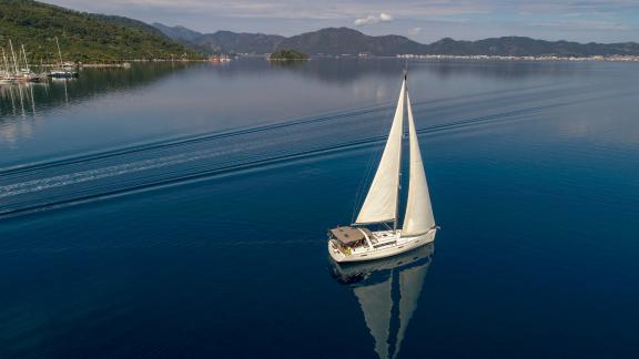 Die Segelyacht Tonic wird während der Fahrt in ruhigen Gewässern in einer friedlichen Bucht gezeigt.