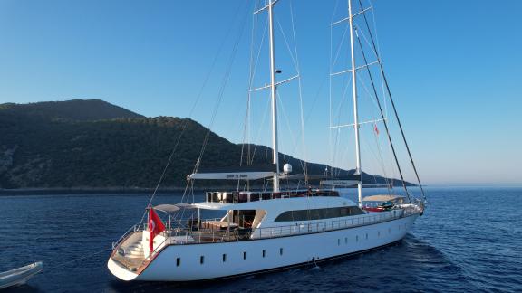 Luxurious motorboat Queen of Makri on clear waters, surrounded by scenic hills in Göcek.