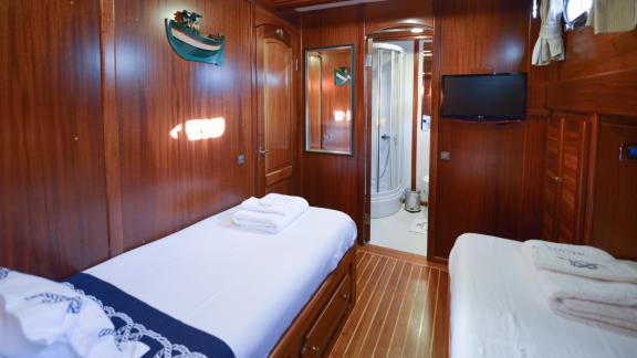 A stylish cabin on the Gulet Ros Mare, equipped with two single beds.