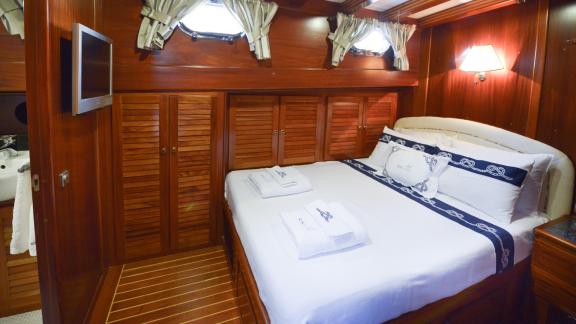 A spacious cabin on the Gulet Ros Mare with a large double bed.