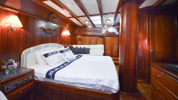 Cabin with double bed, sofa and elegant wooden furnishings.