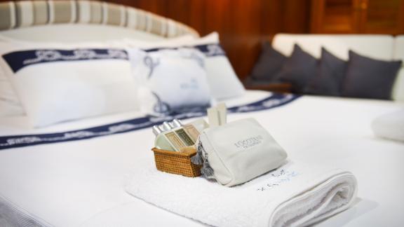 Luxurious care products and towels on an elegant double bed.