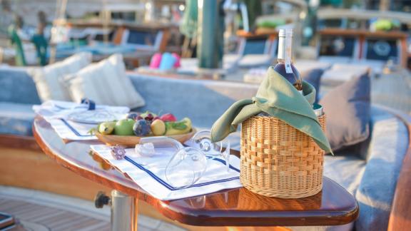 Elegant gedeckter Tisch mit Wein und Früchten auf dem Deck der Gulet Ros Mare.