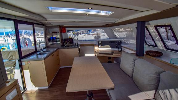 The saloon of the catamaran Sky Maria features a kitchen, spacious table, and seating area.