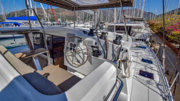 The helm area of catamaran Sky Maria, docked at the marina, offering a wide view.