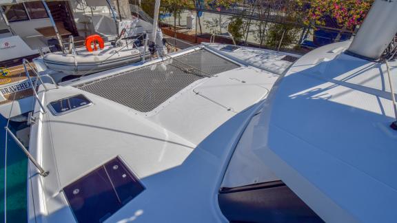 The front deck of catamaran Sky Maria with a netted sunbathing area docked at the marina.
