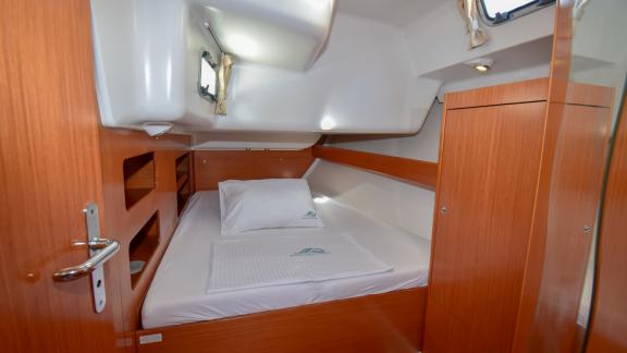 Helle Doppelkabine der Yacht Filyos mit Holzschränken und bequemen Bett, das durch die Fenster erleuchtet wird.