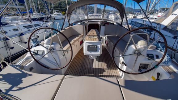 The aft cockpit of sailing yacht Zezo, docked in the marina, features comfortable seating areas.