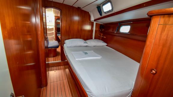 Full view of the double cabin with portholes and large bed